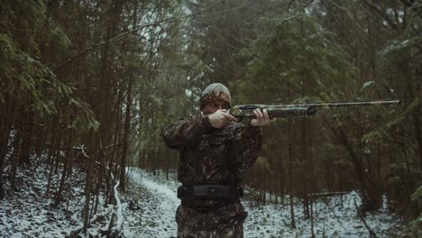 cinematic-follow-video-of-a-man-wearing-camouflage-aiming-and-getting-ready-to-shoot-an-animal-in-the-distance-whilst-walking-slowly-and-calmly-to-his-target-and-trying-to-stay-still-and-composed