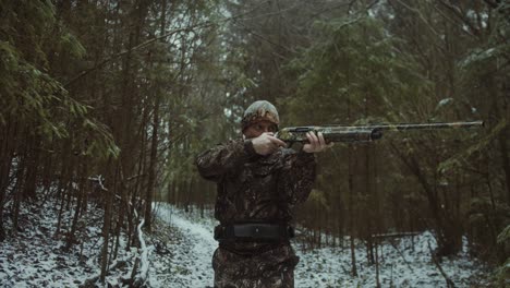 cinematic follow video of a man wearing camouflage aiming and getting ready to shoot an animal in the distance whilst walking slowly and calmly to his target and trying to stay still and composed