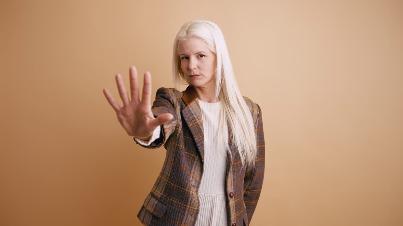 Woman with Blonde Hair Making Stop Gesture with Serious Expression