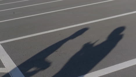 shadows of people on a parking lot