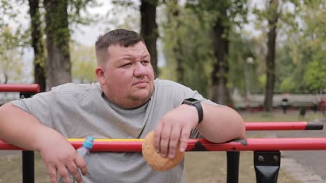 obese man holding burger during morning workout the problem of losing weight junk food obese man holding burger during morning workout the problem of losing weight junk food