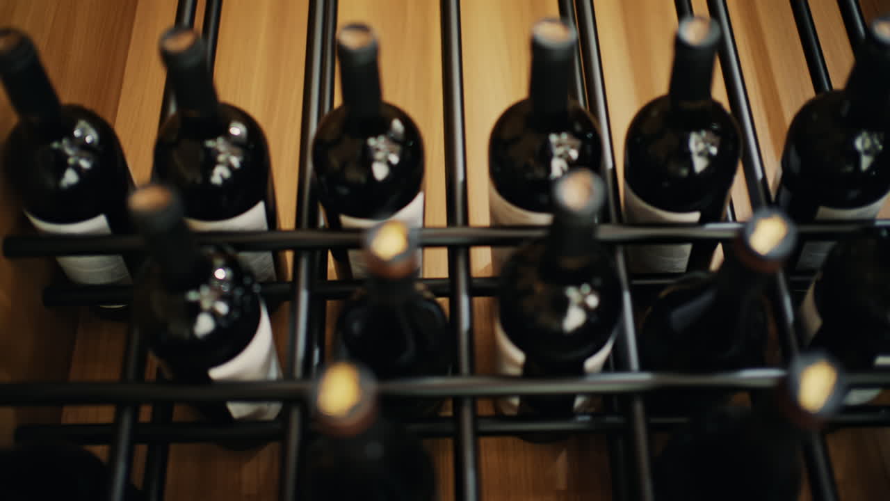 Primo piano di diverse bottiglie di vino disposte in un moderno portabottiglie.