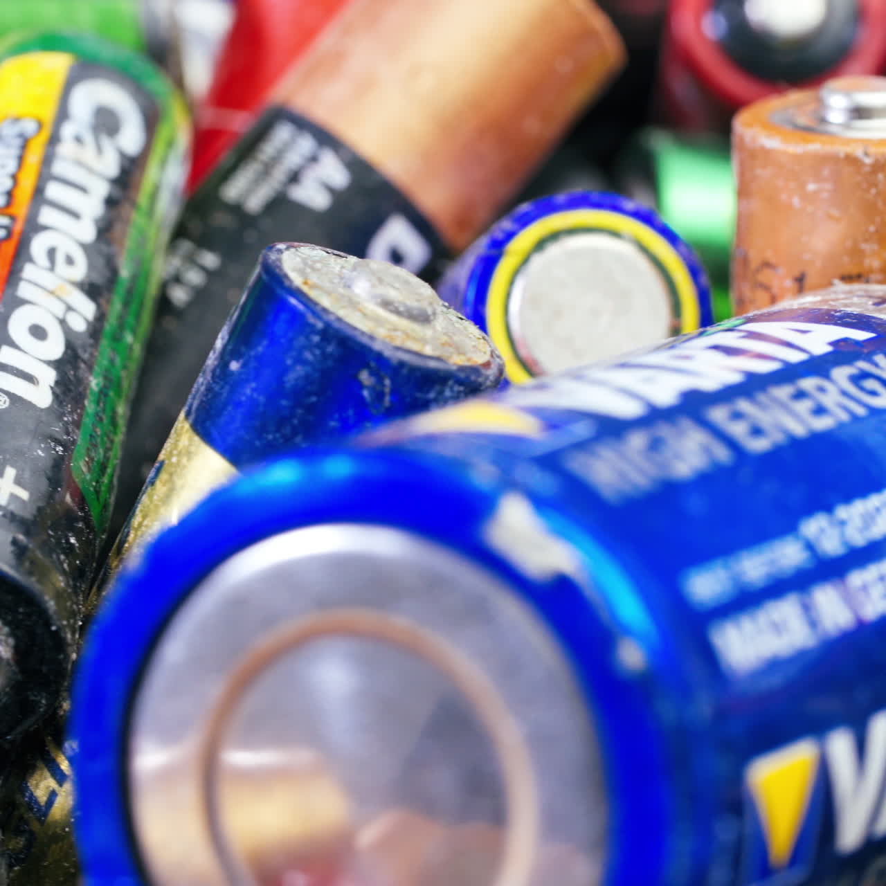 Used batteries from different manufacturers, waste, collection and recycling, high danger for the environment. Batteries background