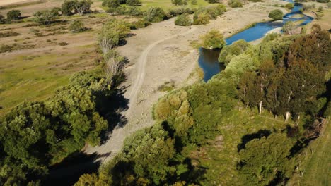 Toma-Aérea-De-La-Orilla-De-Un-Pequeño-Río-En-El-Campo-De-Nueva-Zelanda