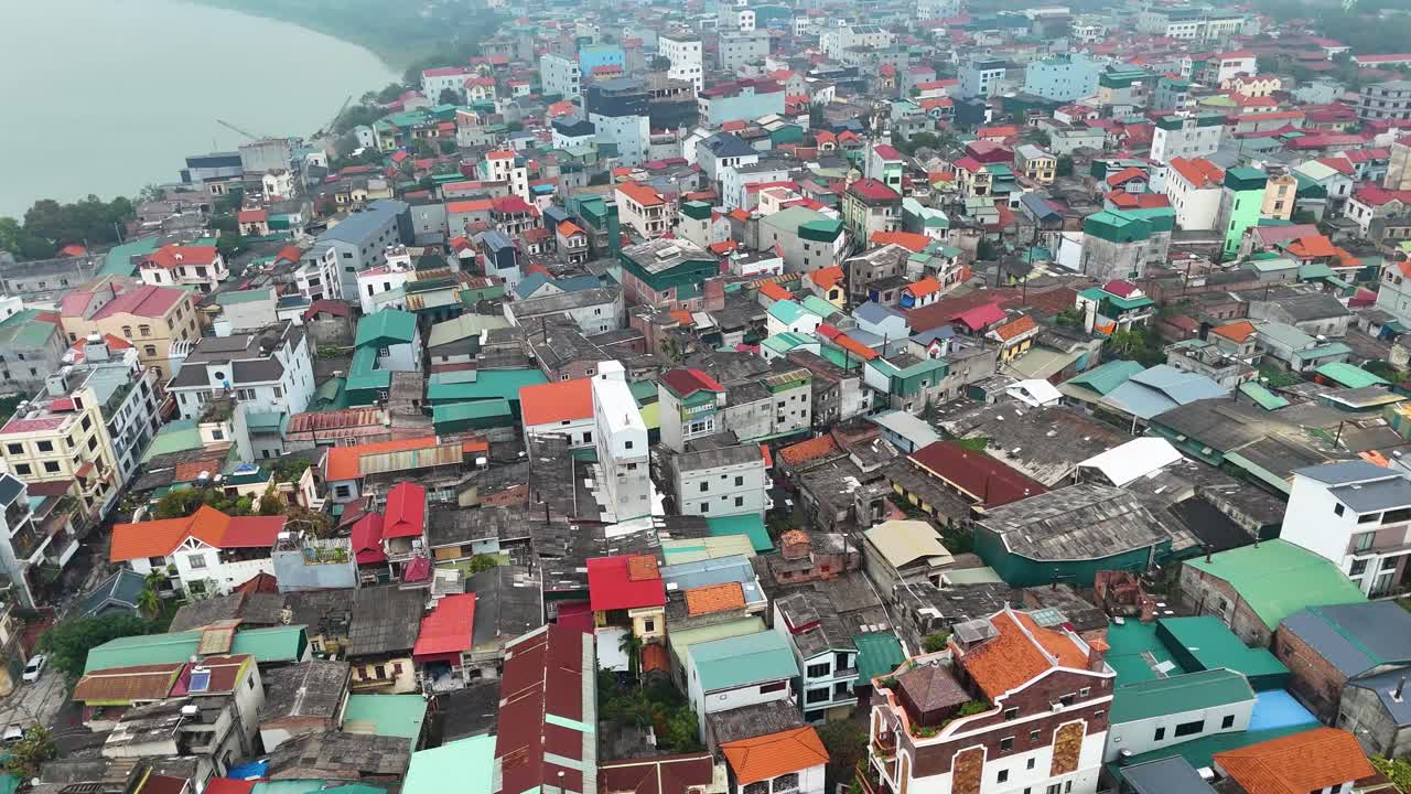 Drone shot of Bat Trang pottery village on the outskirts of Hanoi, Vietnam, showcasing a densely packed urban area with colorful rooftops and narrow streets.