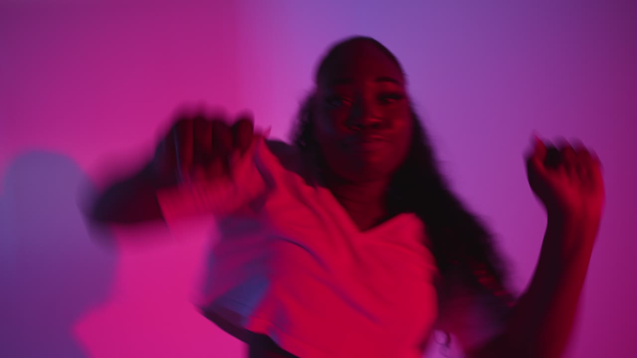 scatto in studio di una giovane ballerina che balla contro uno sfondo illuminato a blu e rosa 8