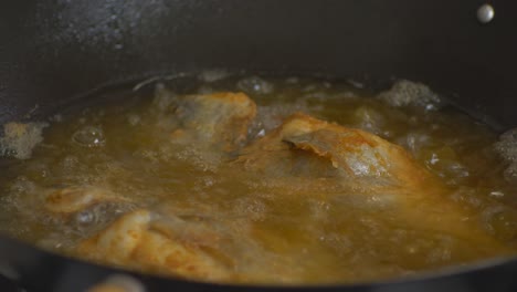deep frying fish in sizzling oil wider shot