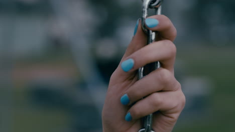 close-up-hands-lonely-woman-on-swing-in-playground-park-swinging-alone-teenage-depression-concept