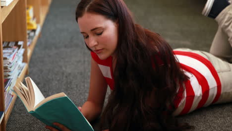 Hermosa-Estudiante-Leyendo-Un-Libro-Tirado-En-El-Suelo-