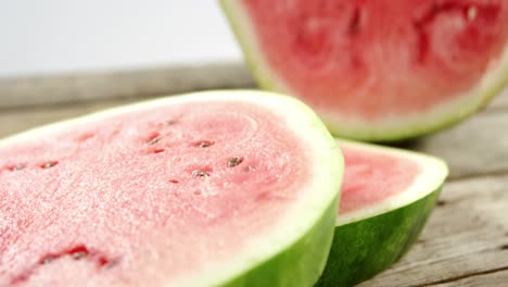 Slices-and-halved-of-watermelon-on-wooden-table