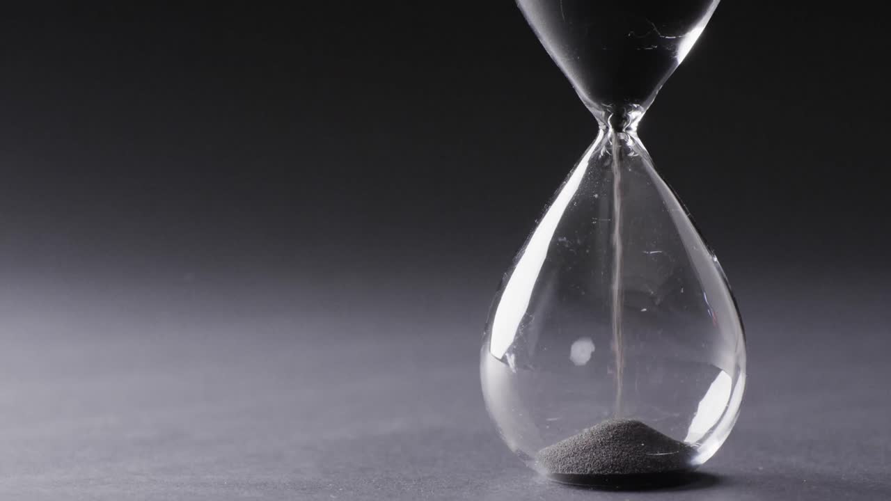 video de reloj de arena con arena vertiendo, copia espacio en fondo negro