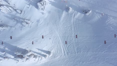 ski chairlift on winter ski slopes, 4k aerial top-down view