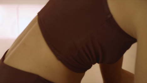 sporty woman looking video lesson on smartphone during yoga workout indoors
