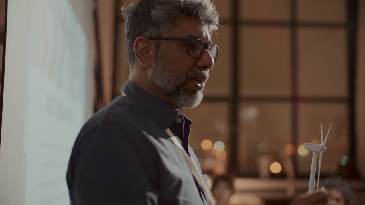 ingeniero sénior presentando el proyecto de energía eólica a la audiencia en una reunión