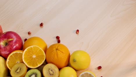 fruits with pomegranate seeds falling onto table