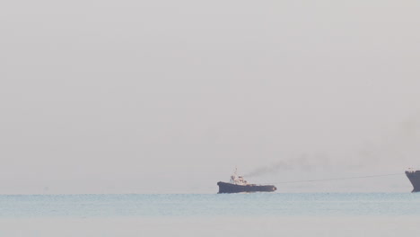 Tugboat-tugging-a-large-barge-in-an-overcast-day