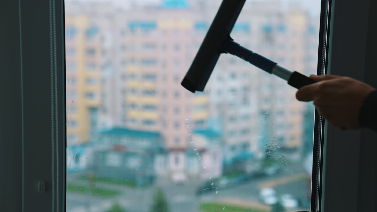 Professional cleaning window indoor. Man cleaning window with special equipment.