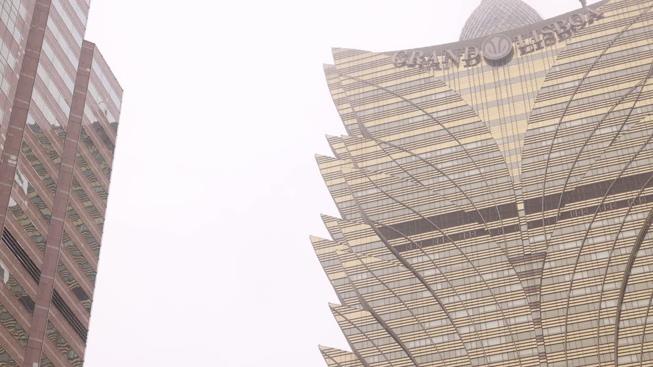 Looking up at the iconic and intricate design of the Grand Lisboa Hotel in Macau, showcasing its modern architecture.