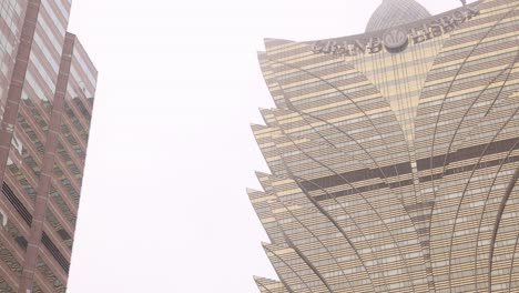 looking up at the iconic and intricate design of the grand lisboa hotel in macau, showcasing its modern architecture.