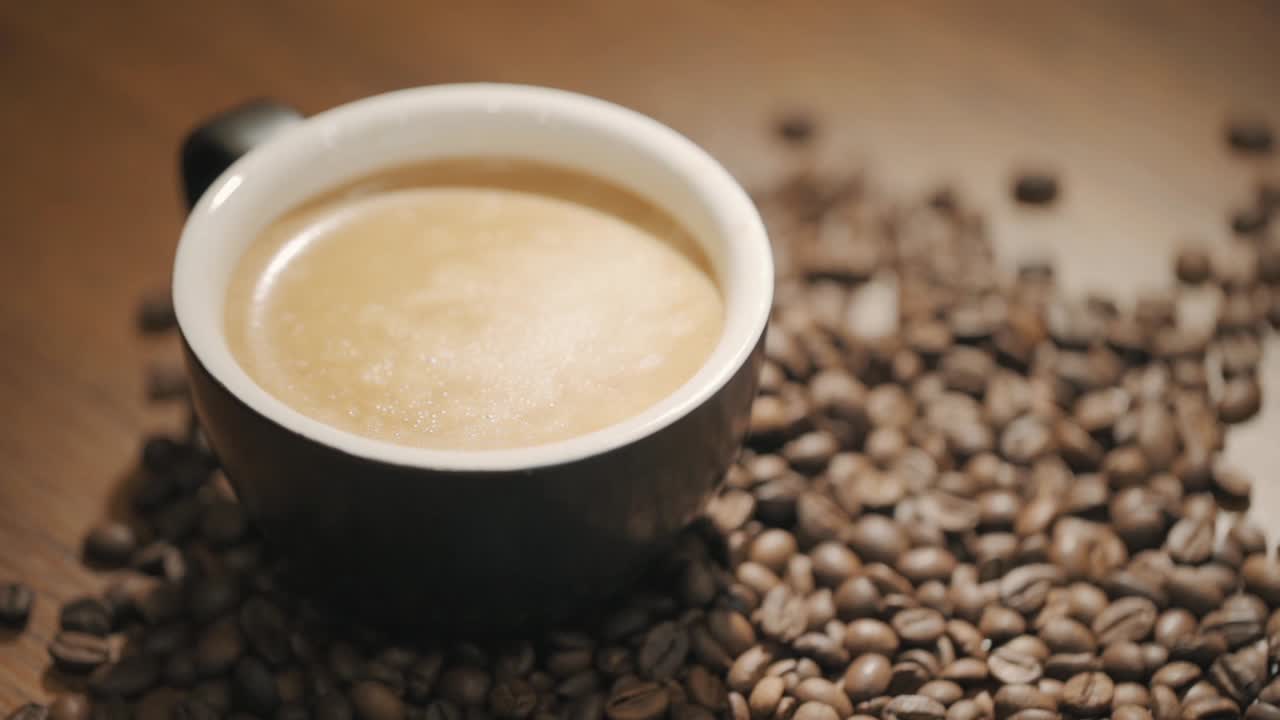 신선한 커피 콩 슬로우 모션으로 둘러싸인 나무 테이블에 커피 한 잔 위에 증기