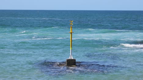 ocean waves crash against a solitary coastal pillar