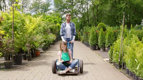 gärtnerin sitzt auf wagen im garten und erledigt papierkram