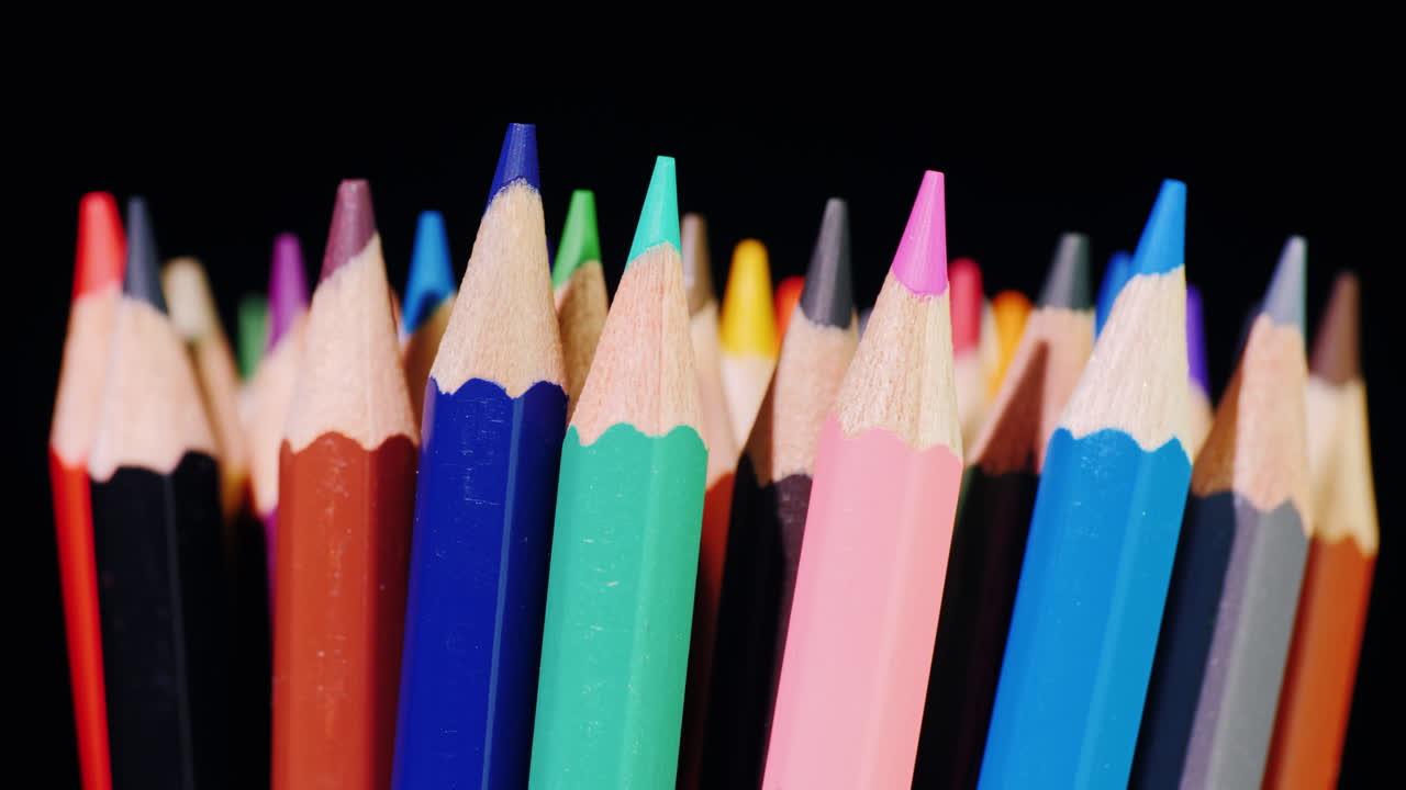 un juego de lápices multicolores sobre un fondo negro