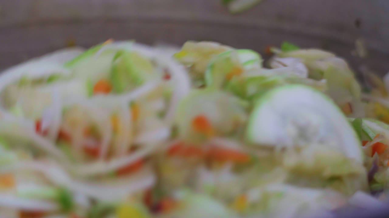 Stirring a vegan saut&eacute; with an aluminum slotted spoon