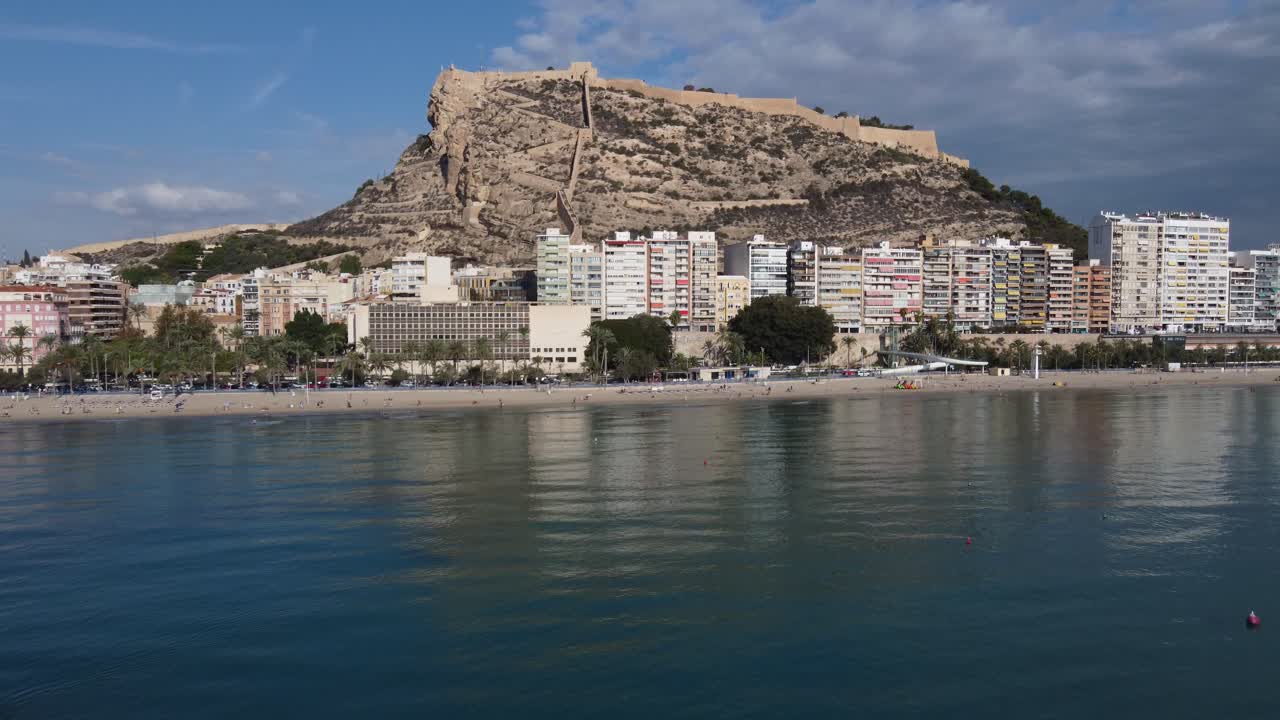 Sideways aerial view of the Postiguet beach and Santa Barbara castle, Alicante, Spain