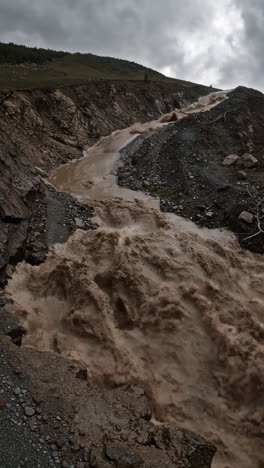 muddy river or flash flood in a rocky landscape
