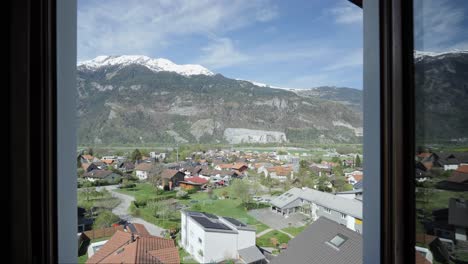 pov vista desde la ventana del hotel en los alpes nevados y el idílico paisaje suizo con una pequeña ciudad