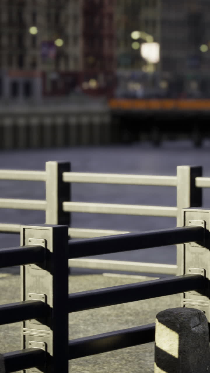 City waterfront promenade with railing and bench during sunset hours