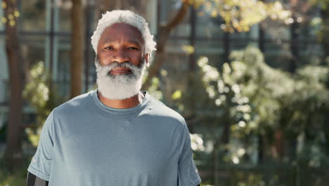 a smiling man with a grey beard in a blue shirt with arms crossed