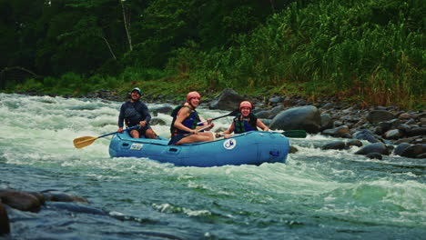 slow motion. group of friends enjoying river rafting in costa rica. paddling and water sports activity.