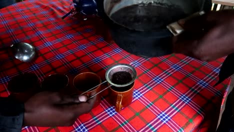 Hand-held-shot-of-fresh-coffee-being-poured-and-strained-into-cups-on-the-Materuni-tour