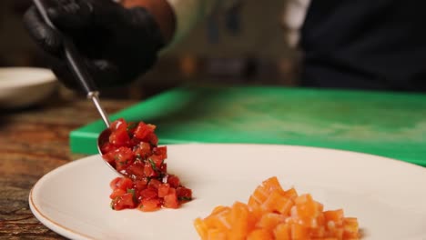 preparando un plato con tomate cortado en cubos y salmón
