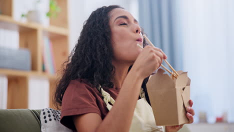 mujer comiendo fideos para llevar en casa