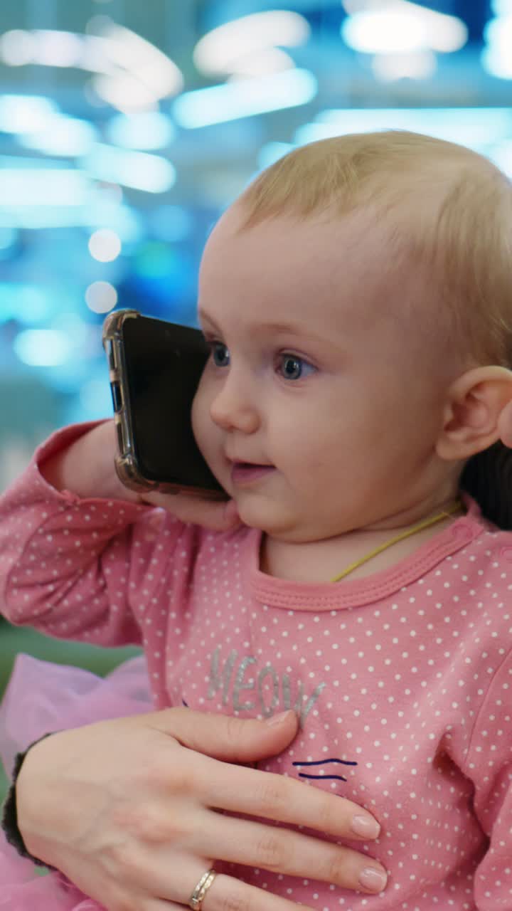 Un niño pequeño adorable interactúa con un dispositivo móvil, mostrando curiosidad y alegría al usar la tecnología, capturado en dos fotogramas secuenciales