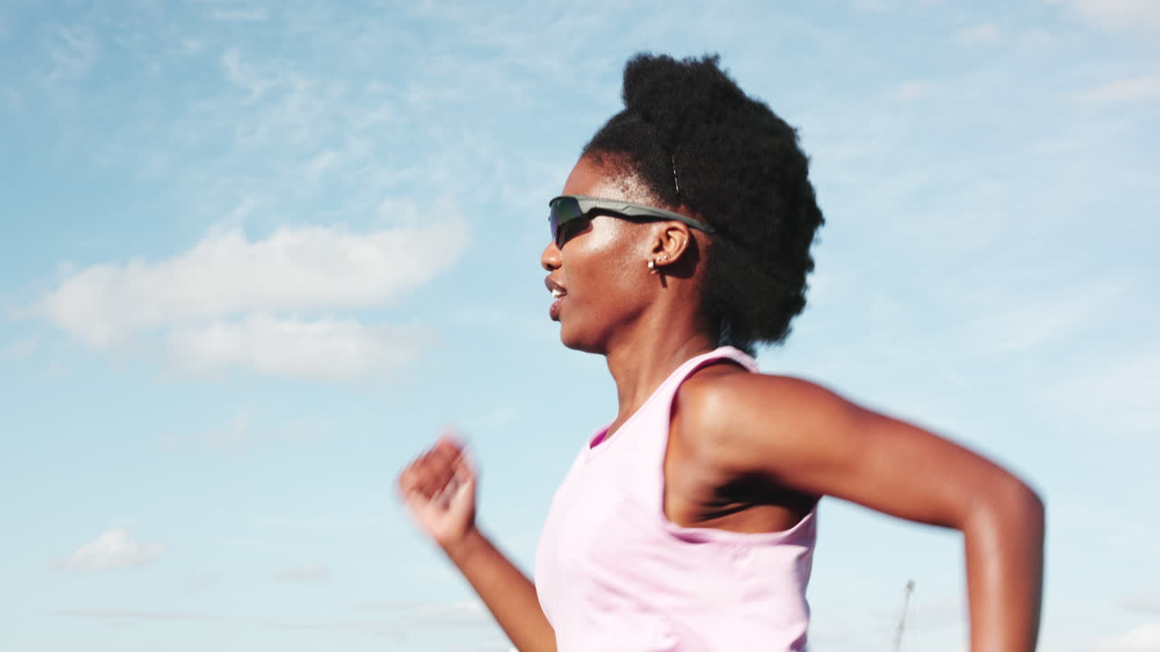 Young Black Woman Running Outdoors Under a Blue Sky