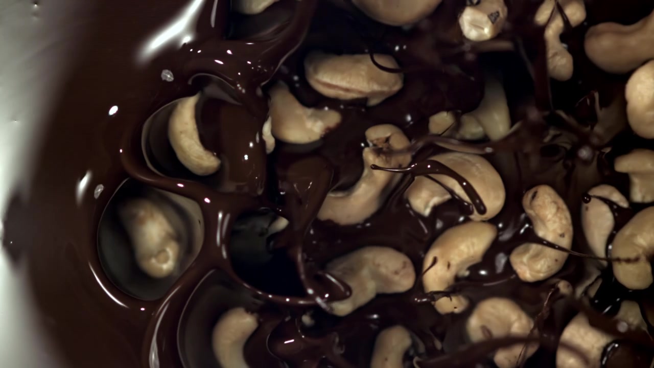 Chocolate Derretido Cobrindo Castanhas de Caju em Câmera Lenta