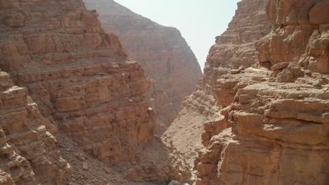 vista de pájaro desde drones atravesando valles rocosos en montañas desérticas, emiratos árabes unidos