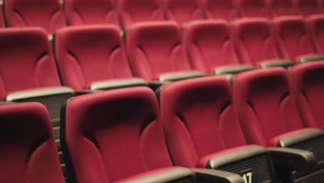 tiro revelador lento de asientos de cine vacíos rojos plegados con números