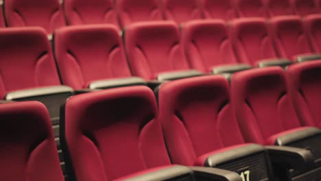 slow revealing shot of folded red empty cinema seats with numbers