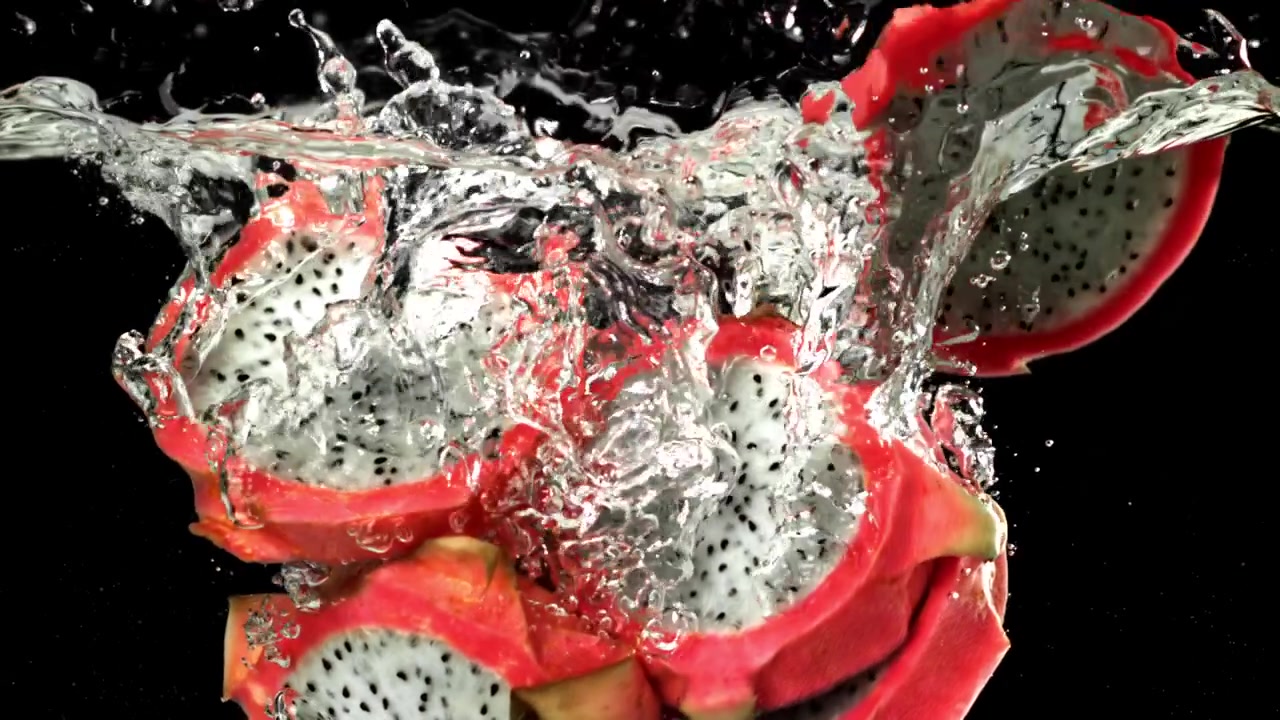 Pitaya a fette che cade nell'acqua con schizzi al rallentatore