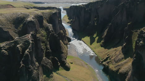 Atemberaubender-Blick-Aus-Der-Luft-Auf-Die-Schlucht-Mit-Dem-Fluss,-Der-Sanft-In-Island-Fließt.-Erstaunliche-Drohnenansicht,-Die-Durch-Eine-Isländische-Schlucht-Fliegt,-Die-Mit-Grünem-Moos-Bedeckt-Ist.-Schönheit-In-Der-Natur