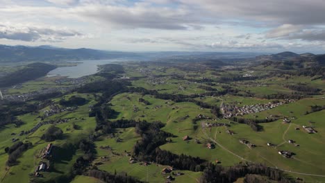 scenic backwards drone shot of active mountain countryside, cars driving down road