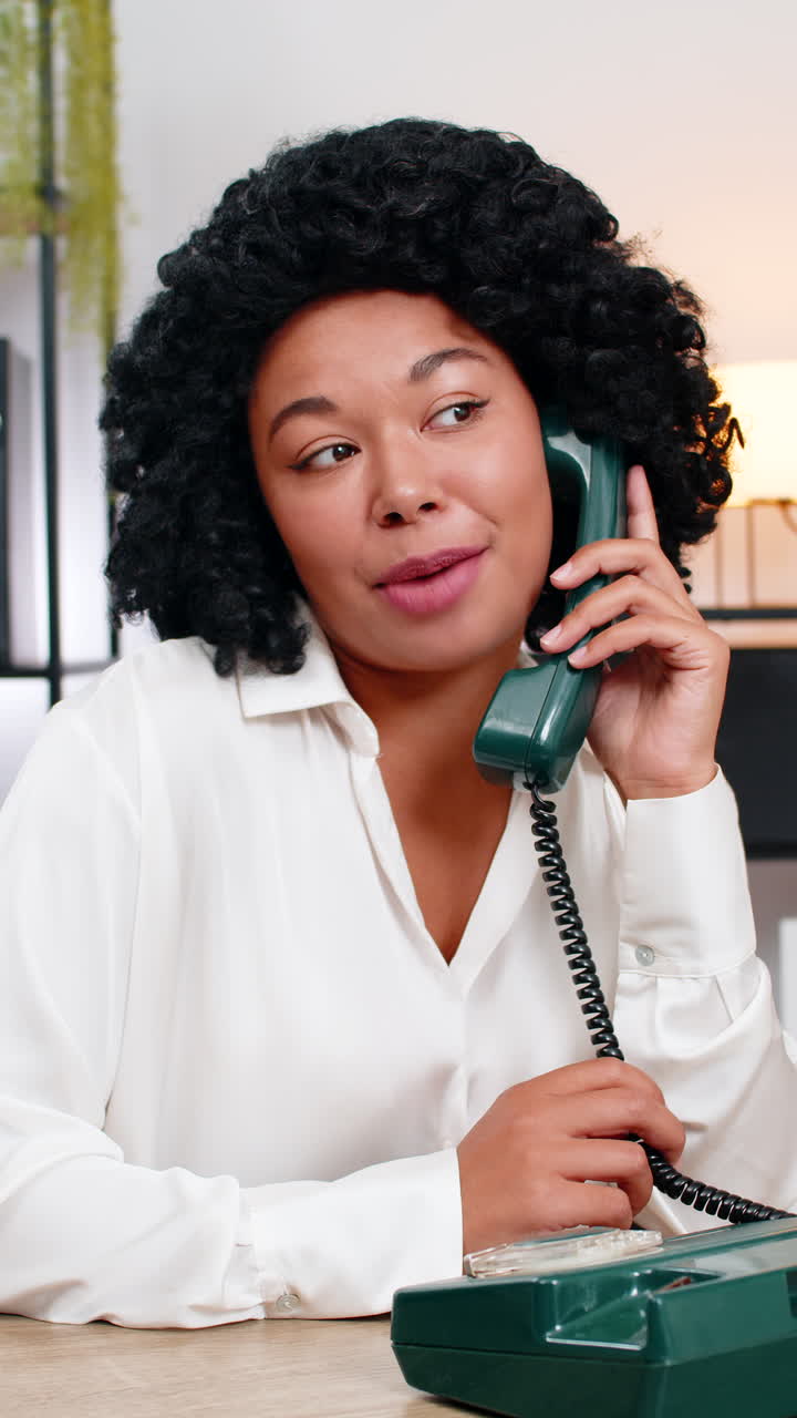 African american businesswoman laughs talking on retro old phone smiling kindly during client call