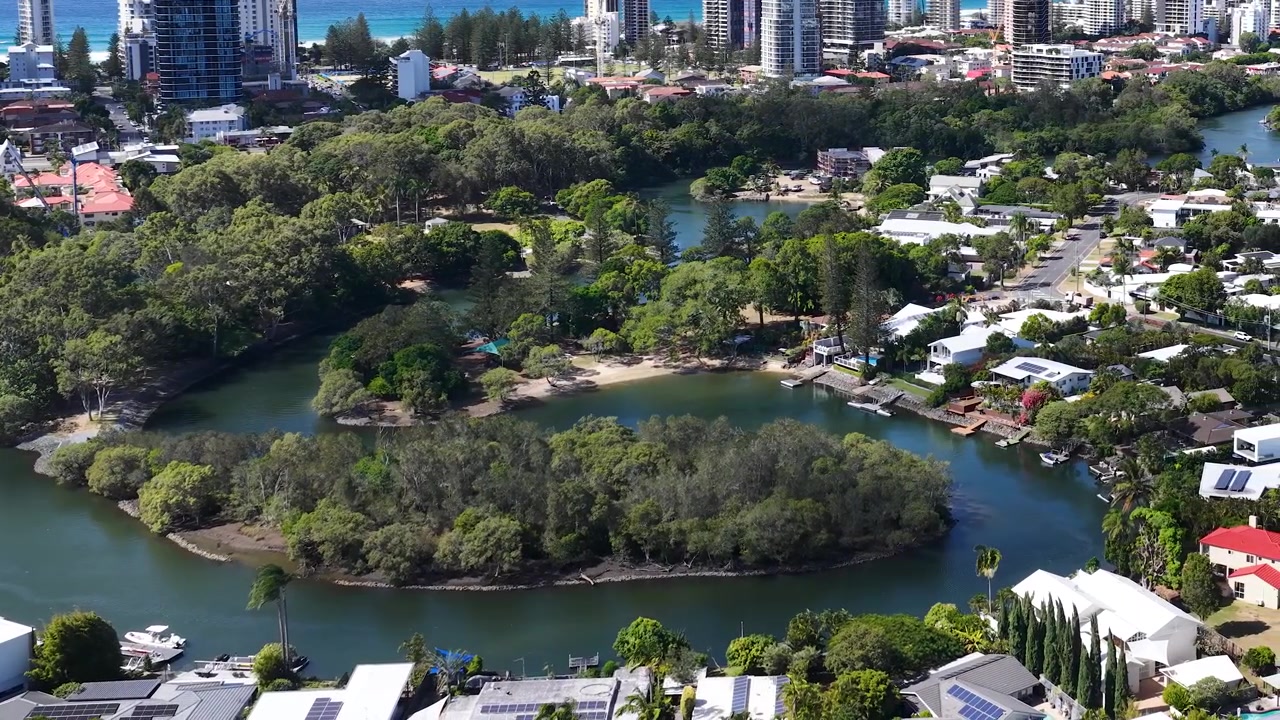 Ripresa aerea dall'alto di un fiume serpeggiante e di una vegetazione lussureggiante vicino a edifici costieri urbani