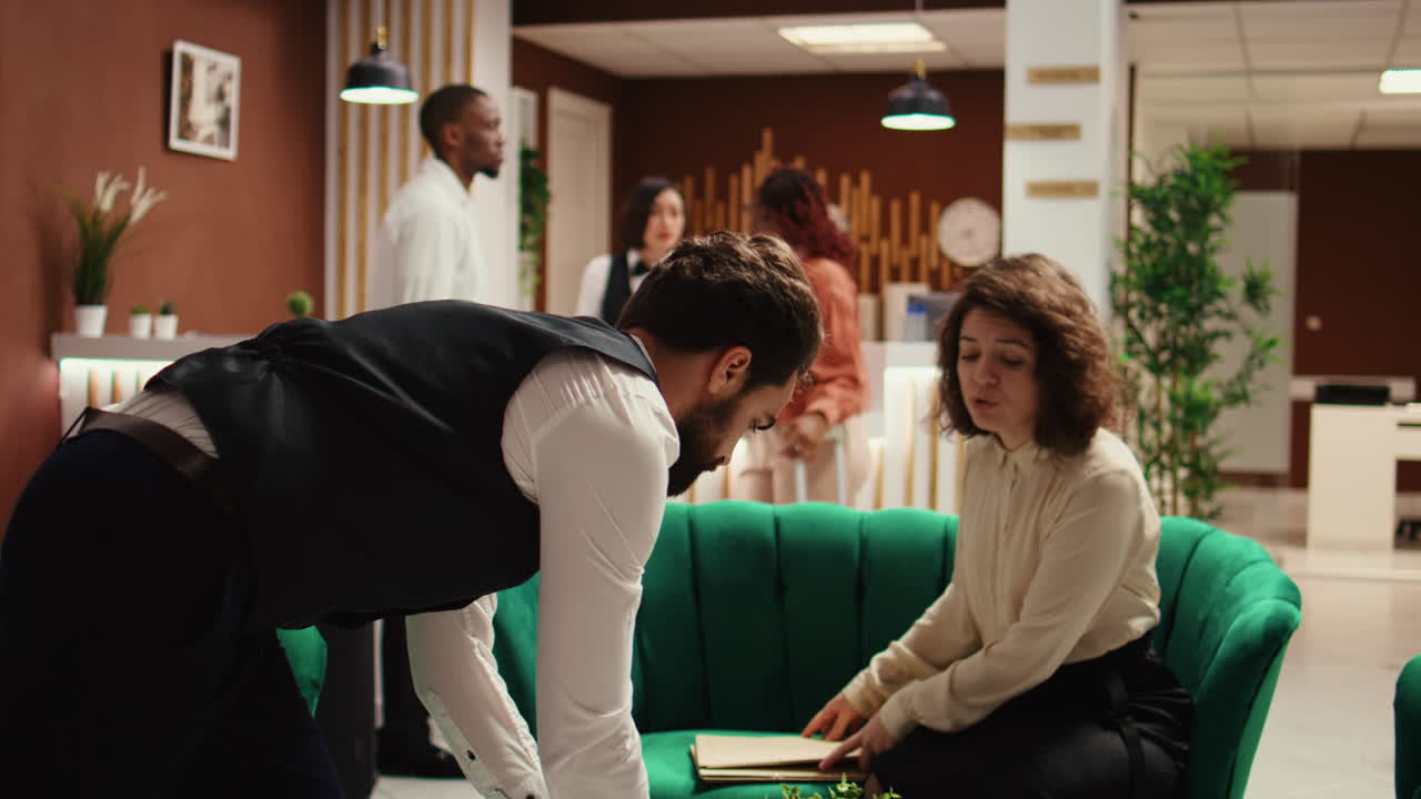 Receptionist offering room key to guests