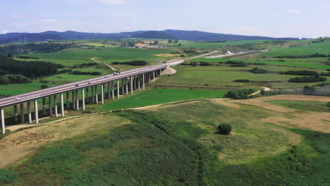 Aerial-view-of-European-route-E50-highway-through-green-agricultural-fields-landscape-connecting-European-continent,-Levoca